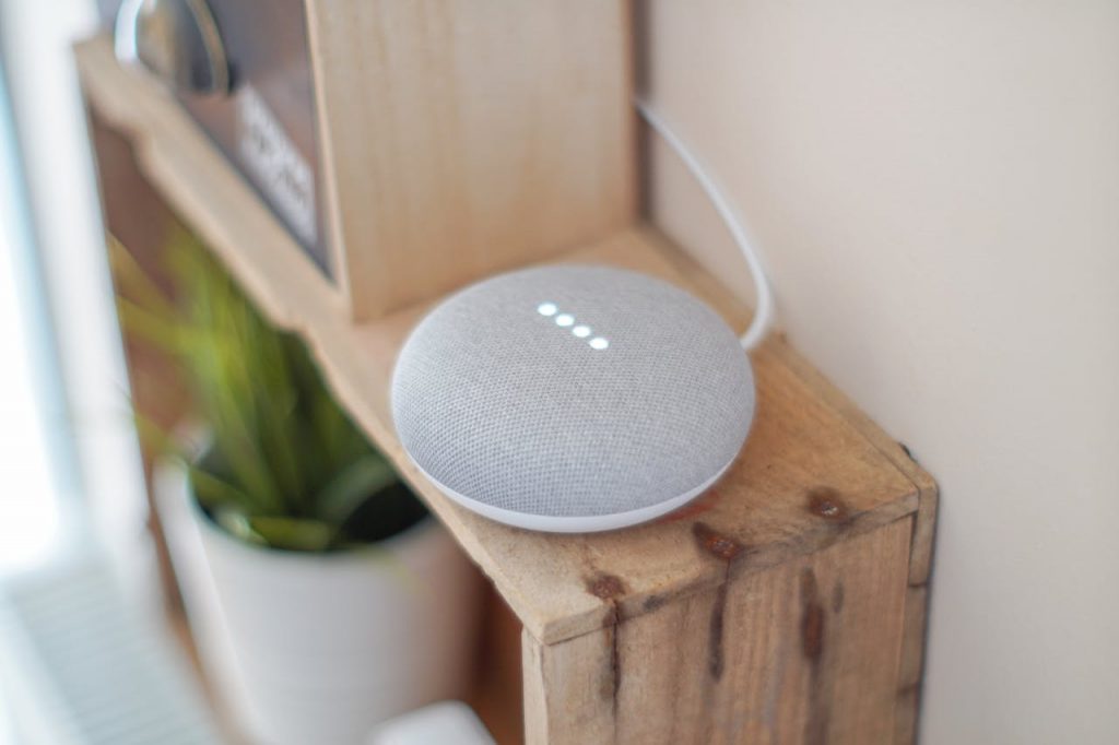pexels-photo-1072851 A Google Home Mini smart speaker on a wooden shelf, blending technology with home decor.