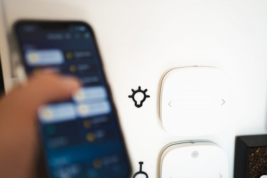pexels-photo-17018384 Blurry smartphone controlling smart home tech on a wall.